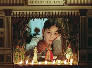 <em>Fanny and Alexander</em>, 1982. In the opening scene, Alexander (Bertil Guve) plays The Three Musketeers with his puppet theater, echoing Bergman&rsquo;s youth. "Ej blot til lyst" above the archway is Danish for "Not just for pleasure," giving an indication of Bergman's intent with this film. Photo: Arne Carlsson, (c) Svensk Filmindustri