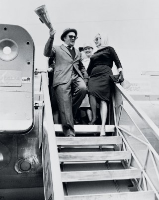 On the set of 'La dolce vita' (1960). Federico Fellini shows Anita Ekberg how to disembark from an aeroplane like a movie star.