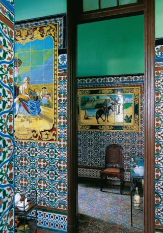Inside Cuba Jair Mon Pérez House in Havana: The sober tiled walls of the kitchen contrast with the colourful mosaic of Goya's 1792 work "Muchachos trepando a un árbol", visible in the background.