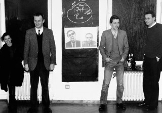 Julia Dacic, Martin Kippenberger, Albert Oehlen, Max Hetzler with the Kippenberger/Oehlen multiple <em>Durchgangslager Felix Kull</em>, Erhard Klein Gallery, Bonn, 1984. Foto: Wilhelm Sch&uuml;rmann