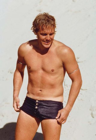 Bunker in silver arm bands and custommade H. Miura surf trunks, Jeffreys Bay, South Africa, winter 1975